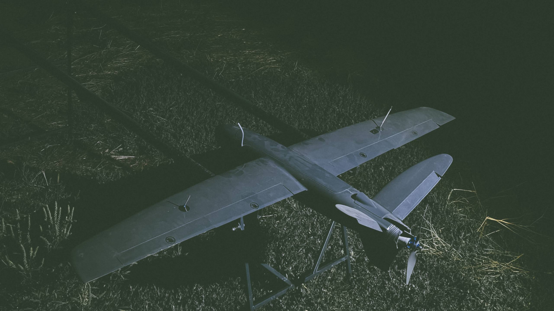 Fixed-wing unmanned aerial system positioned on a grass field